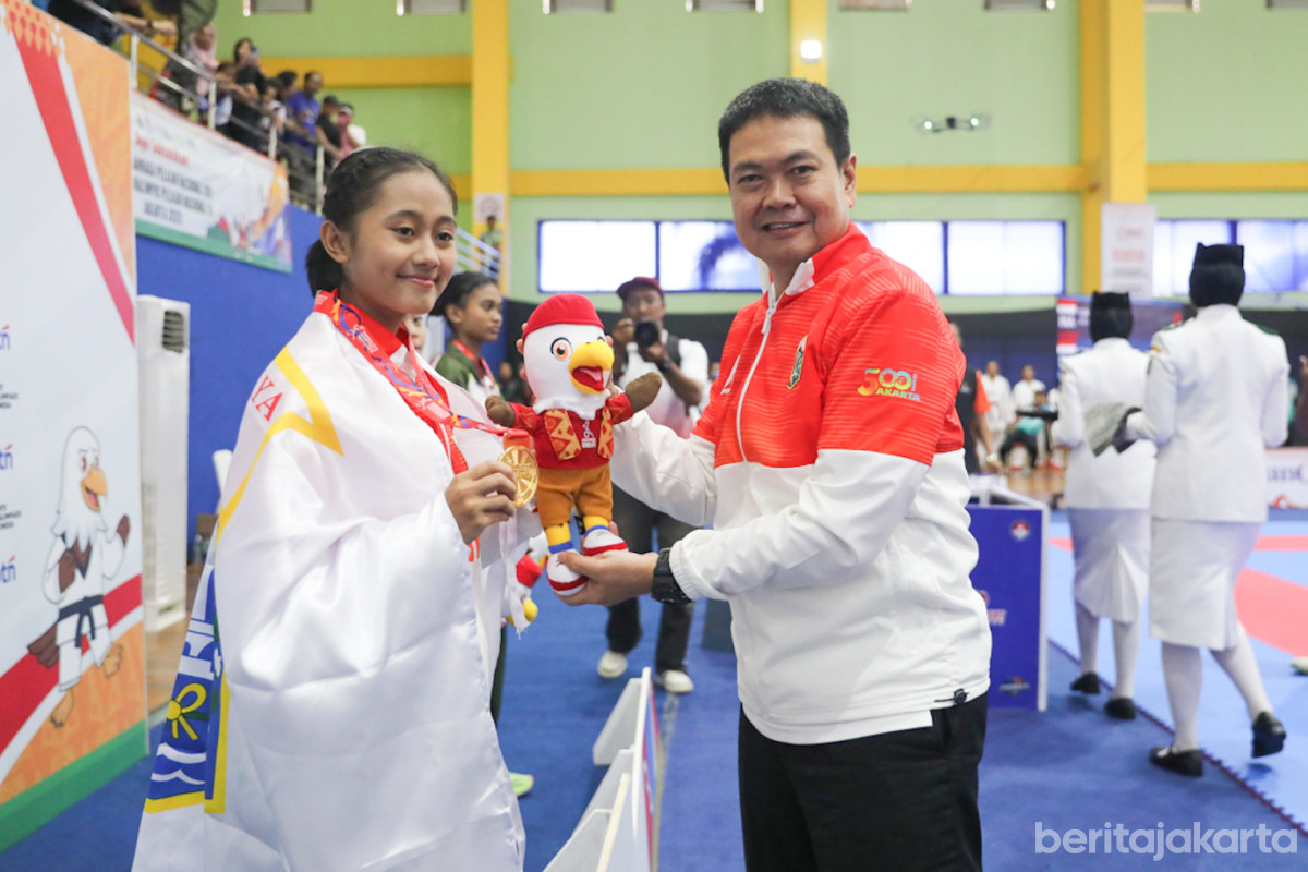 Kadispora, Andri Yansyah mengalungkan medali emas kepada salah satu atlet karate pelajar DKI