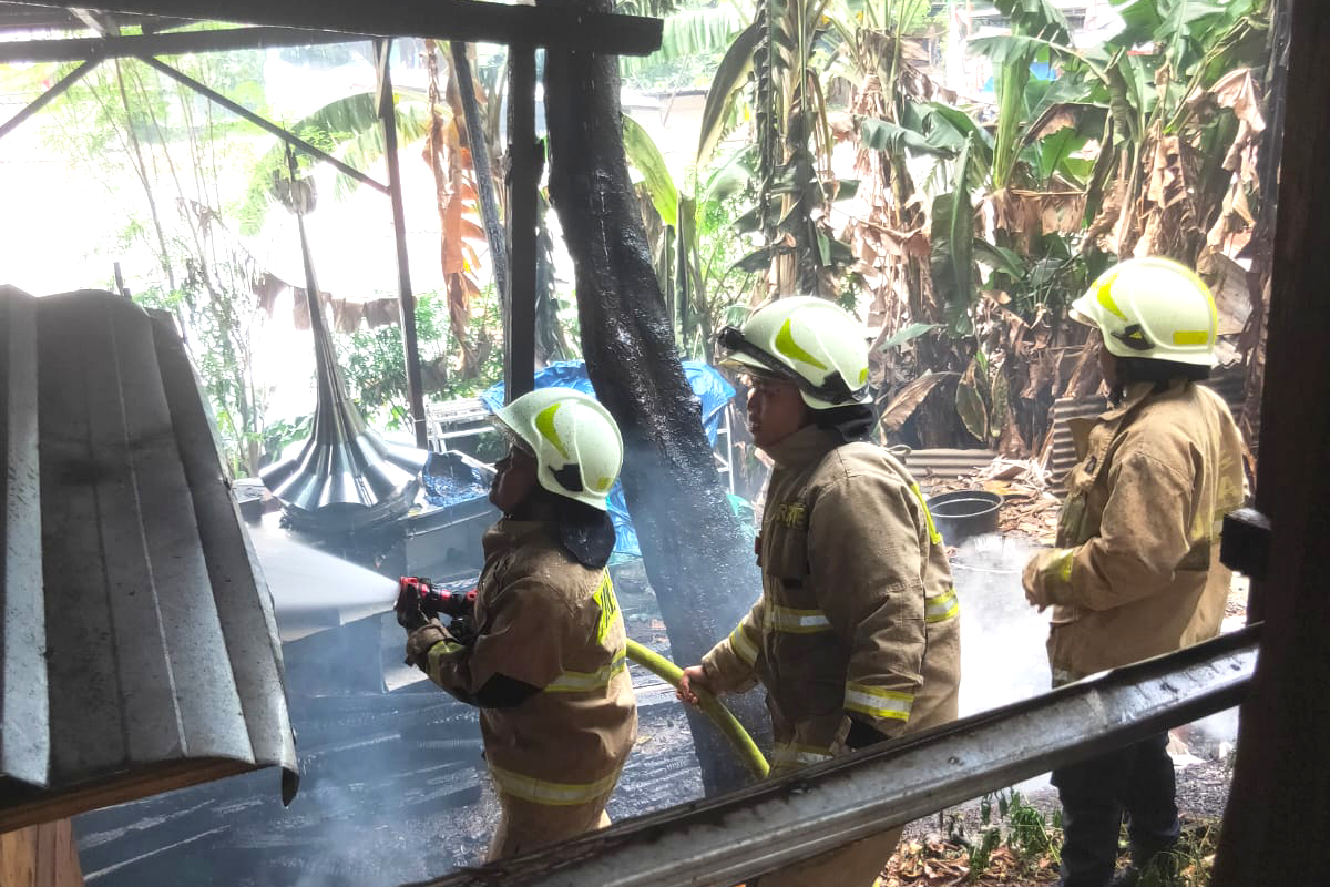 Petugas melakukan pendinginan di area yang terbakar