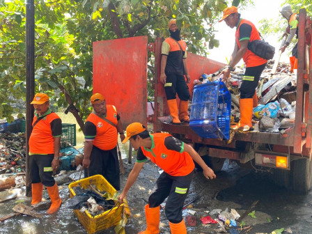 Petugas UPS Badan Air Bersihkan Lingkungan Pasca Banjir di RW 03 Pegangsaan Dua