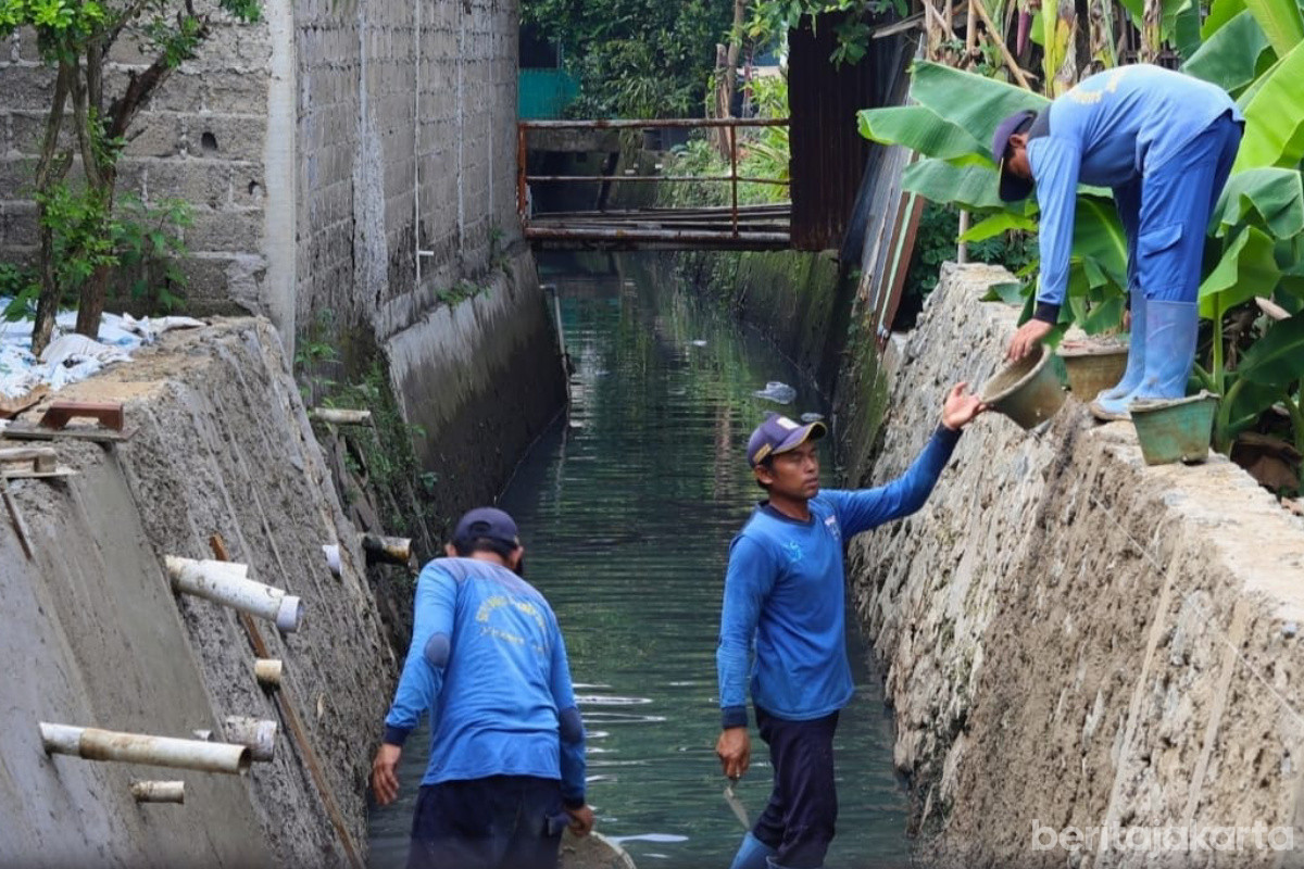 Sejumlah petugas melakukan perapihan dinding turap dengan semen