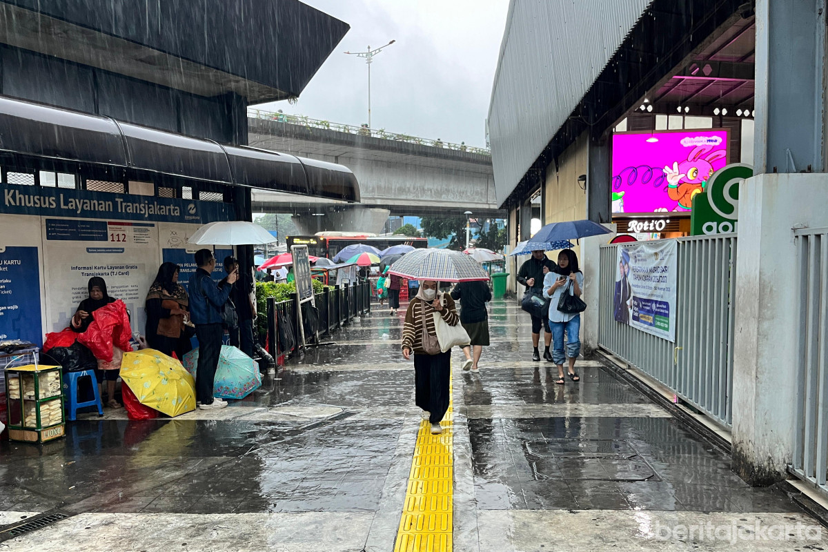 Warga beraktivitas dengan payung saat cuaca hujan di kawasan Tanah Abang