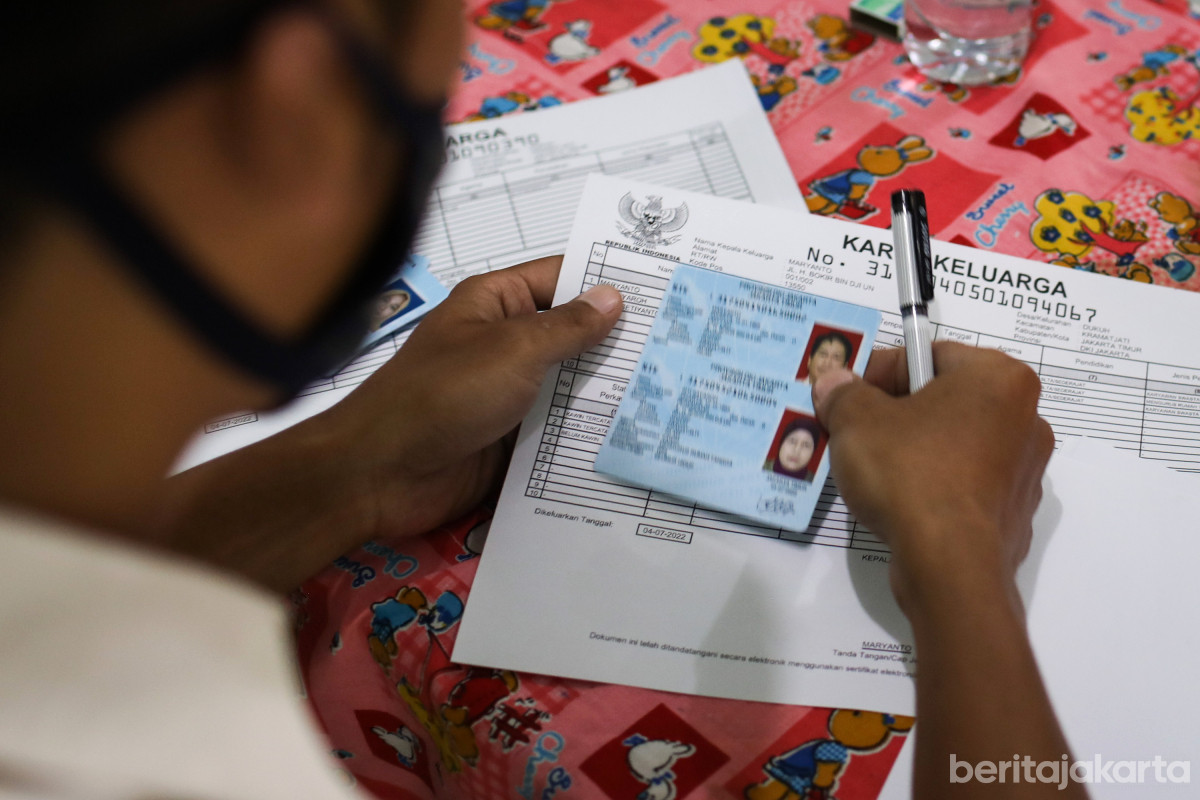 Petugas melakukan pencocokan data KTP dan KK warga