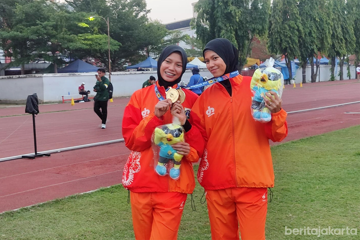 Devi Aprilian dan Diva Aprilian menunjukkan medali emas cabang olahraga atletik yang mereka peroleh