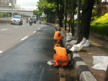 PPSU Karet Semanggi Bersihkan Tali Air di Jl Gatot Subroto