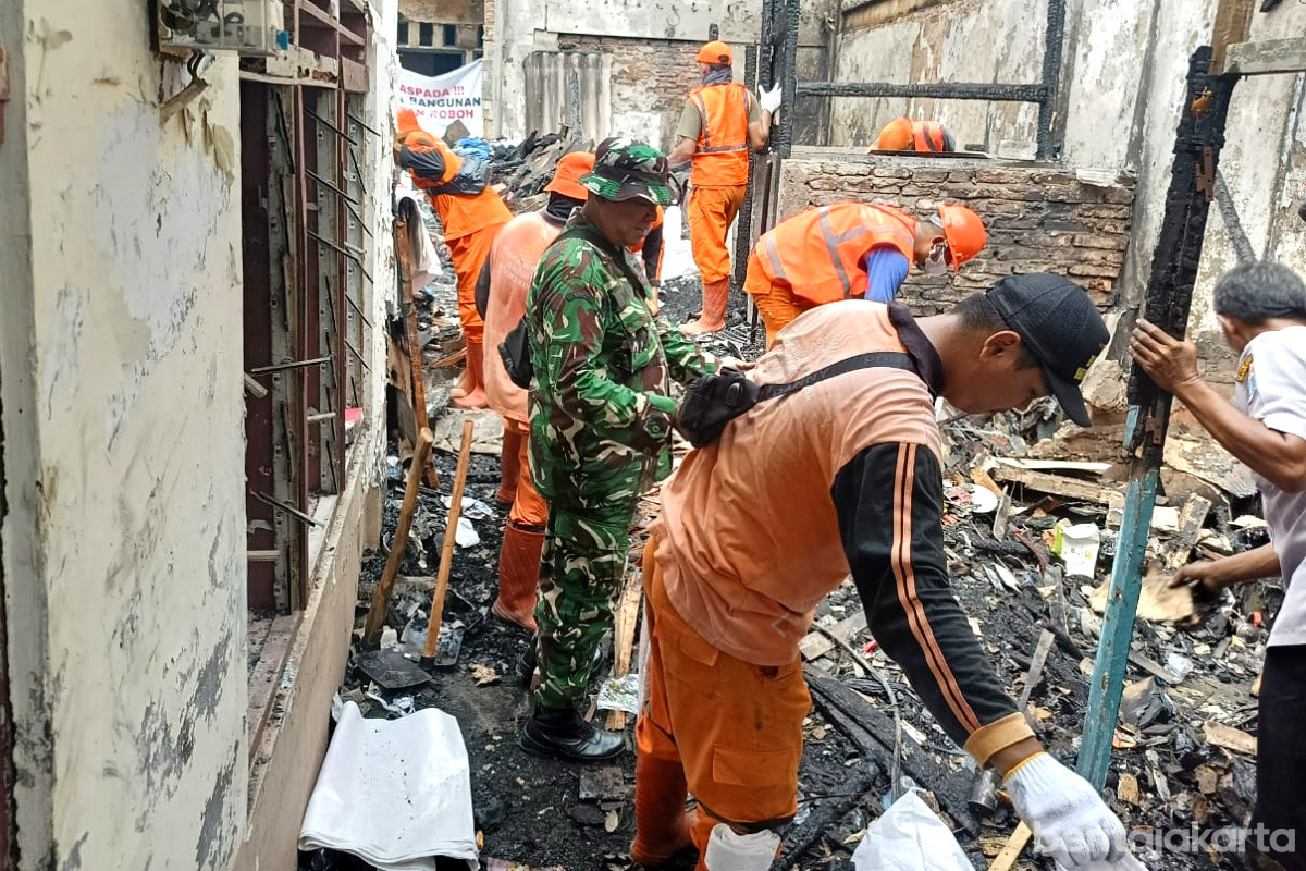 Petugas gabungan membersihkan puing sisa kebakaran di Angke